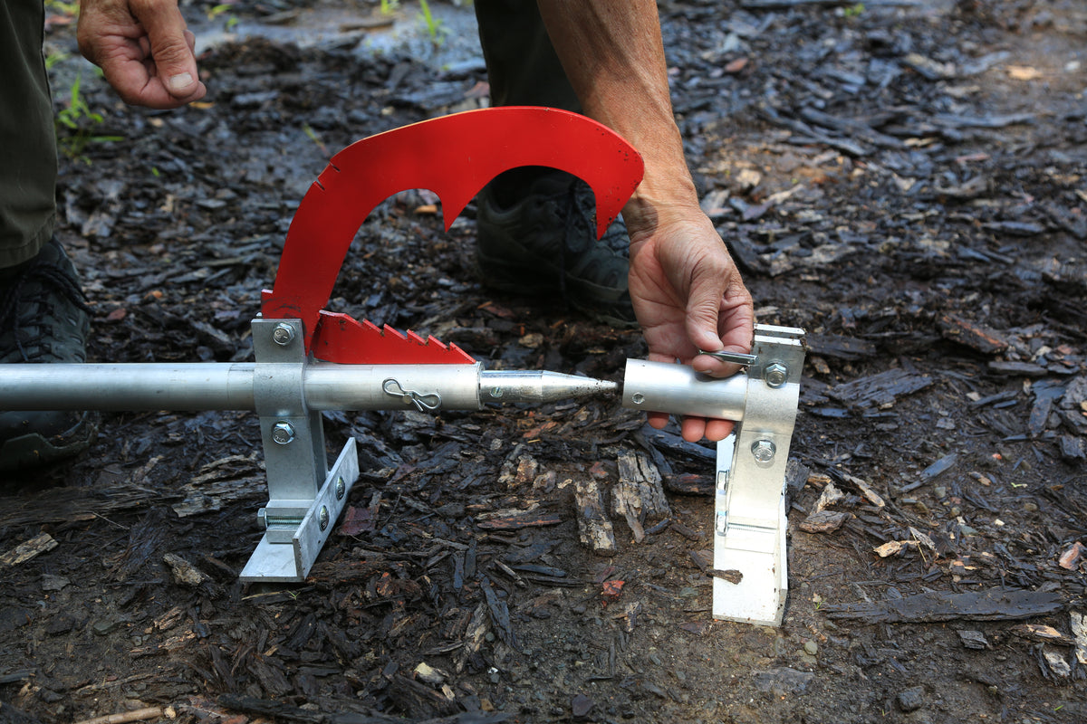Hands fitting the removable bottom foot onto a Woodchuck DualPro, with the cant teeth and peavey point in view